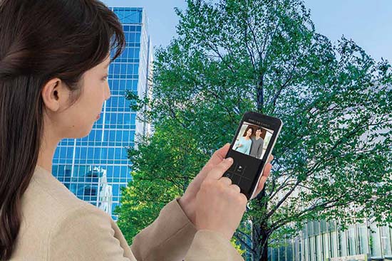 スマートフォンでインターホンの来訪者を確認するようす